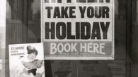 Sign Of The Times: 1939 Don’t Mind Hitler: Take Your Holiday Via Nationaal Archief: Poster in a London travel agency advising people to book their holidays in spite of the tense situation in Europe (Hitler,...